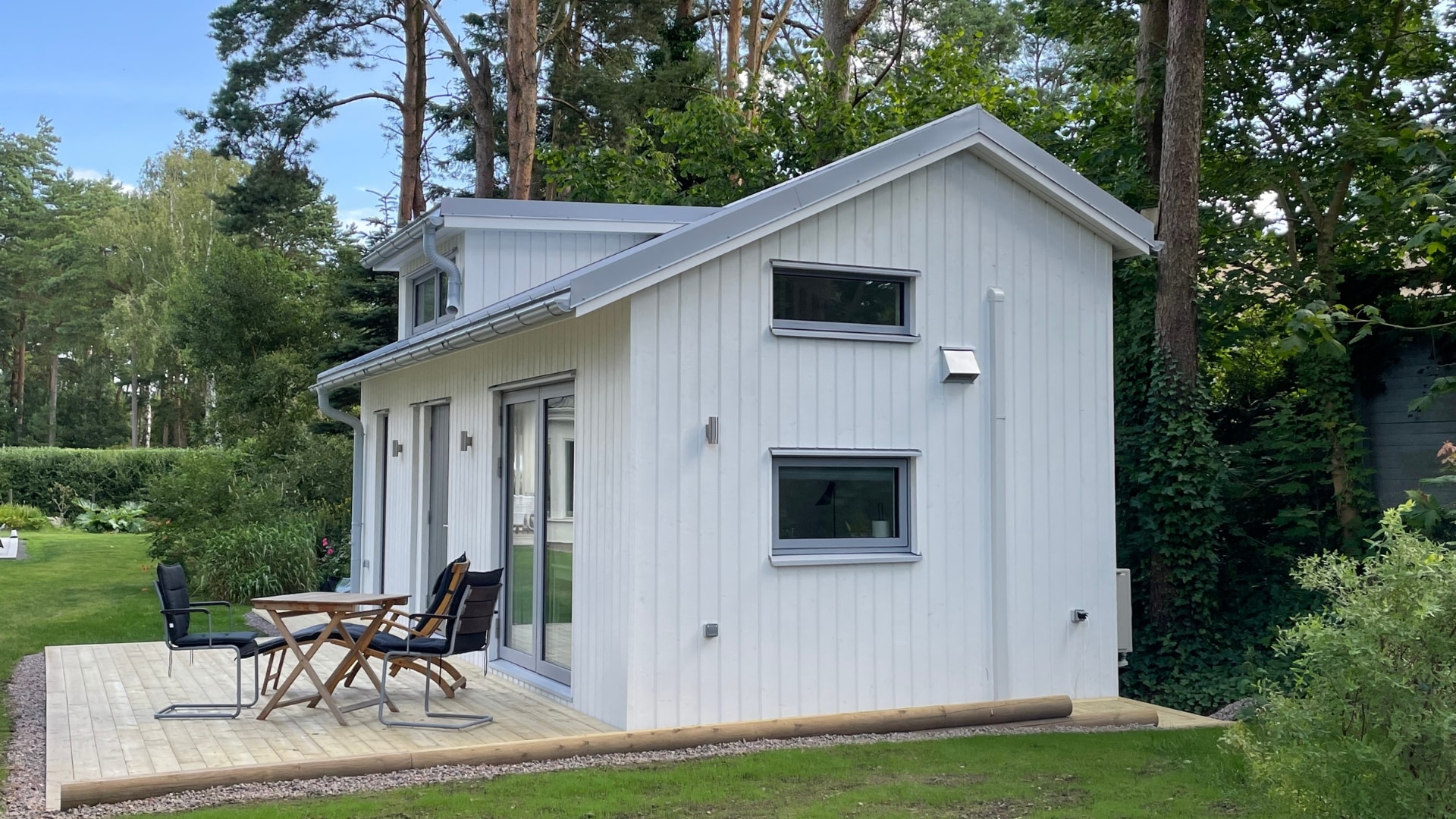 Vit attefallshus med altan